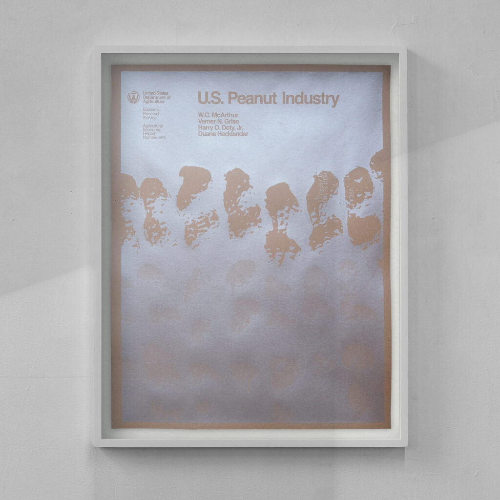 A white framed silkscreen print of a report cover titled US Peanut Industry shows silver ink on brown craft paper